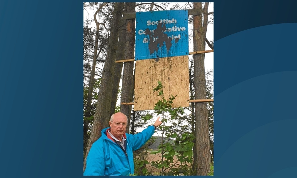 Tony Miklinski, Conservative candidate for North East Fife, with one of the defaced banners.