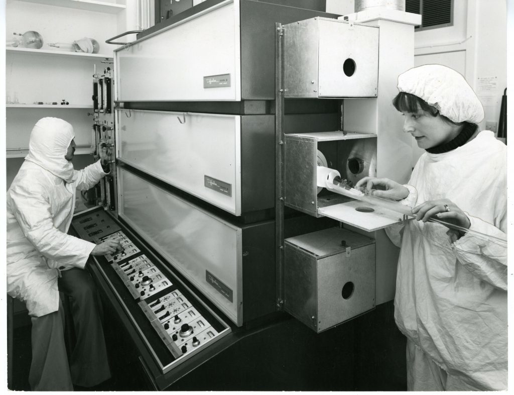 Mrs Catherine Woolridge and research student Mr Jim Boal operating the silicon defusion furnaces in the microelectronic lab clean room in the Dept of Electrical Engineering and Electronics, Dundee University, 1979 H254 1979-03-XX UoD Microelectronic Laboratory (C)UNKNOWN