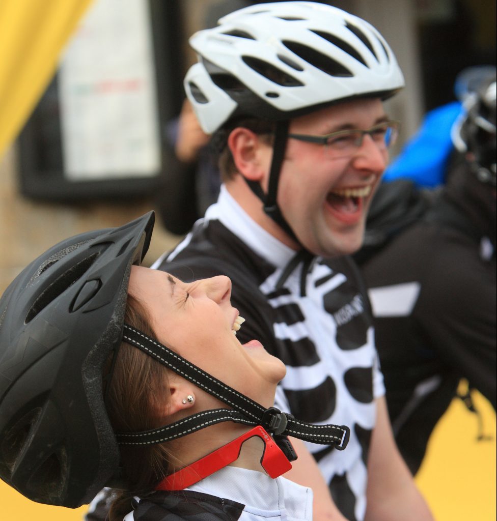 Cyclists share a joke at the start.