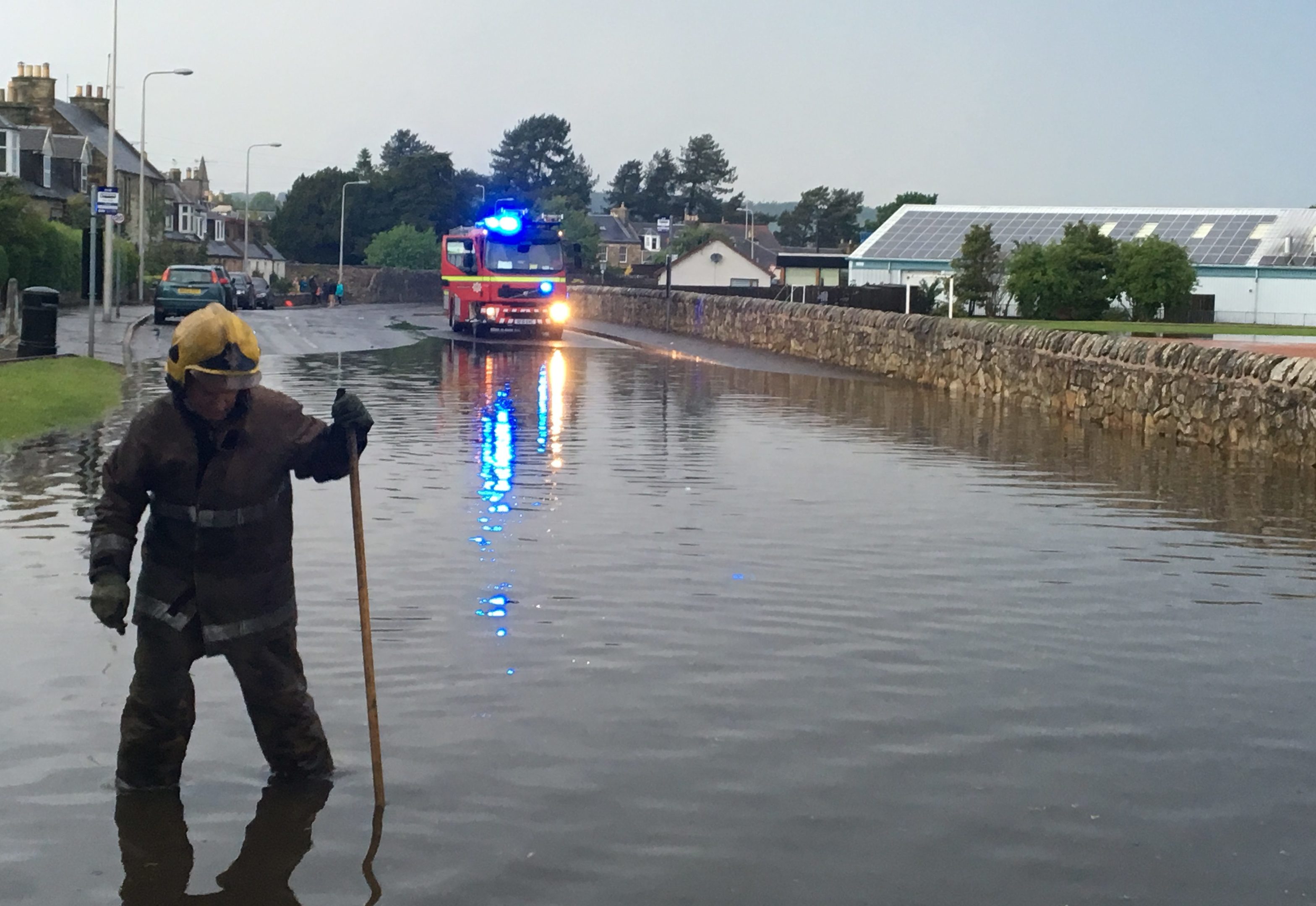 Firefighters work hard to unblock drains after flash floods in Ceres Road, Cupar, on Saturday,