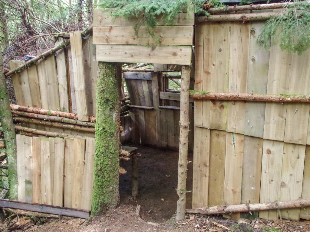 The exterior of the sizeable woodland hut created within the woods.