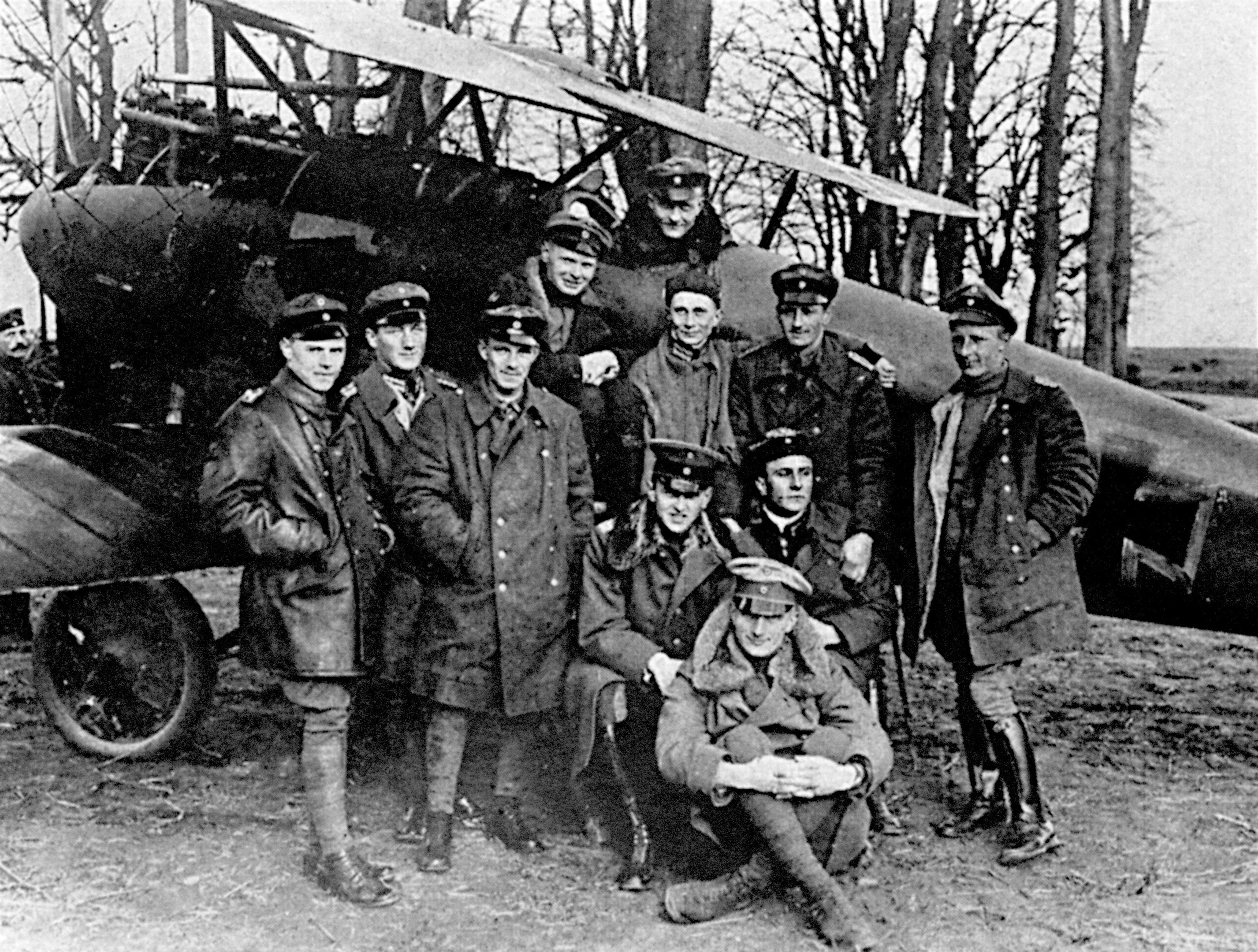 Baron Manfred Freiherr Von Richthofen sits in the cockpit of his Albatros fighter for a photograph with his squadron, Jagdstaffel III.
