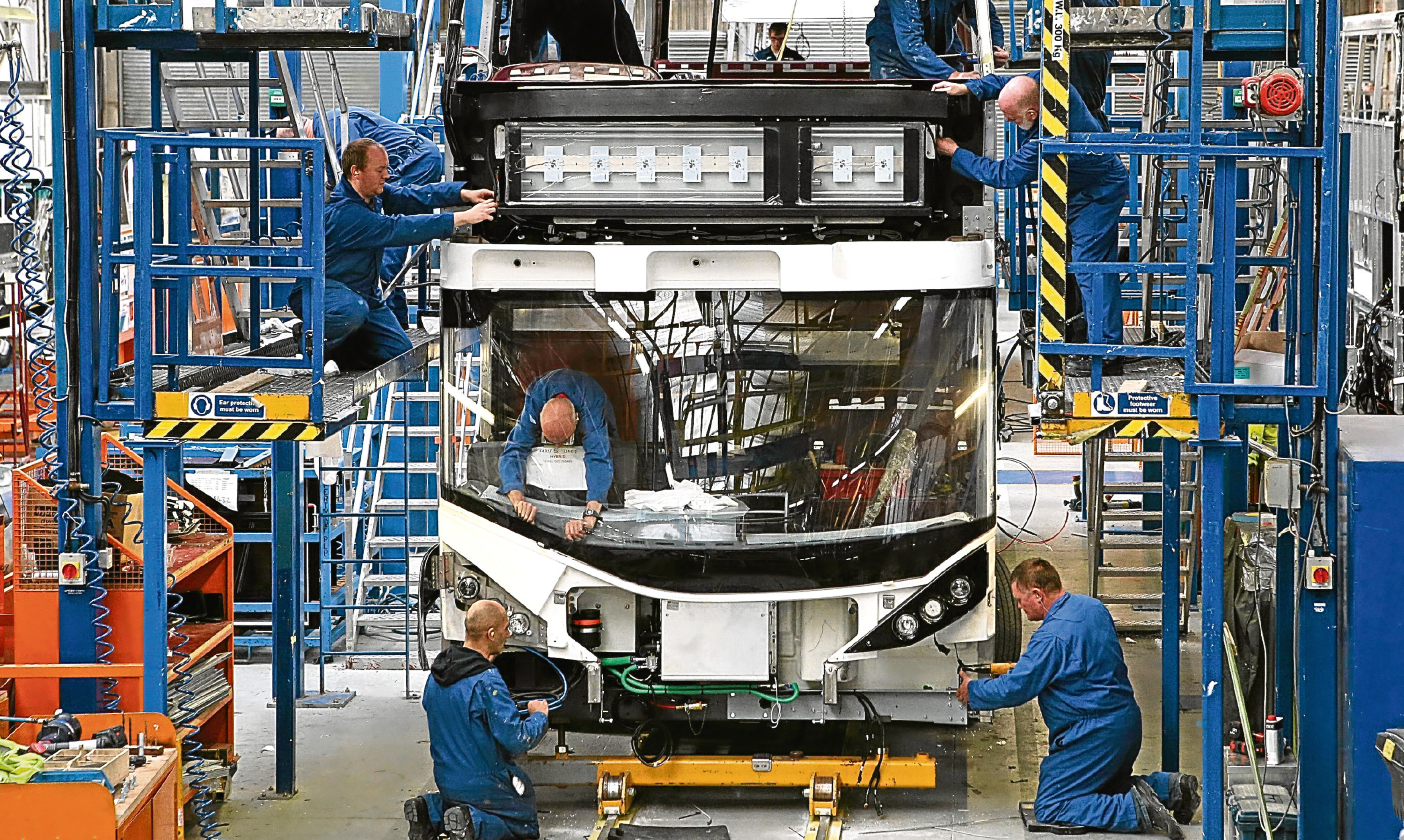 Alexander Dennis technicians work on a new bus build.