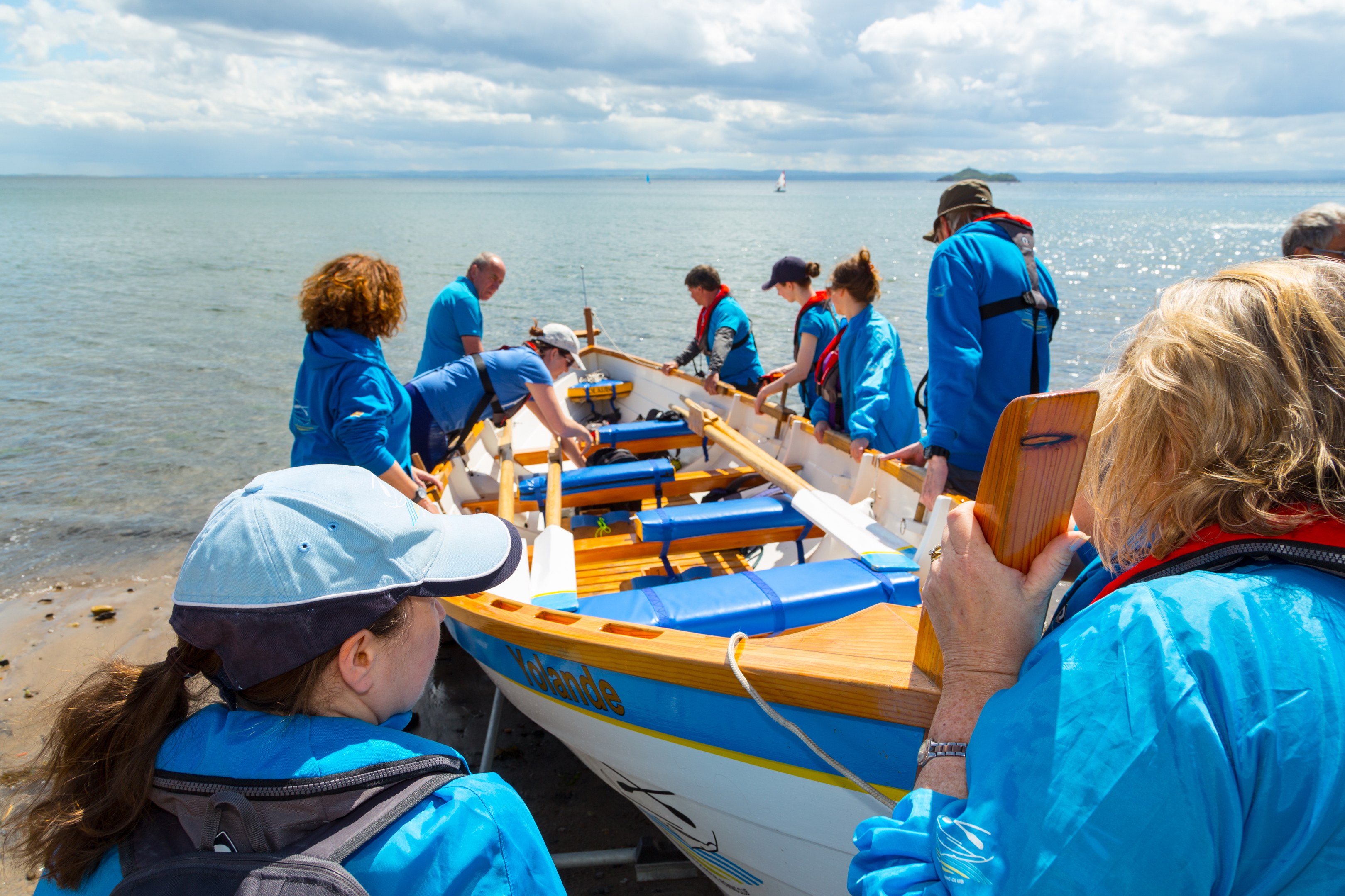 Members of Kinghorn Coastal Rowing Club preparing the boat on their one year anniversary of their first boat launch.