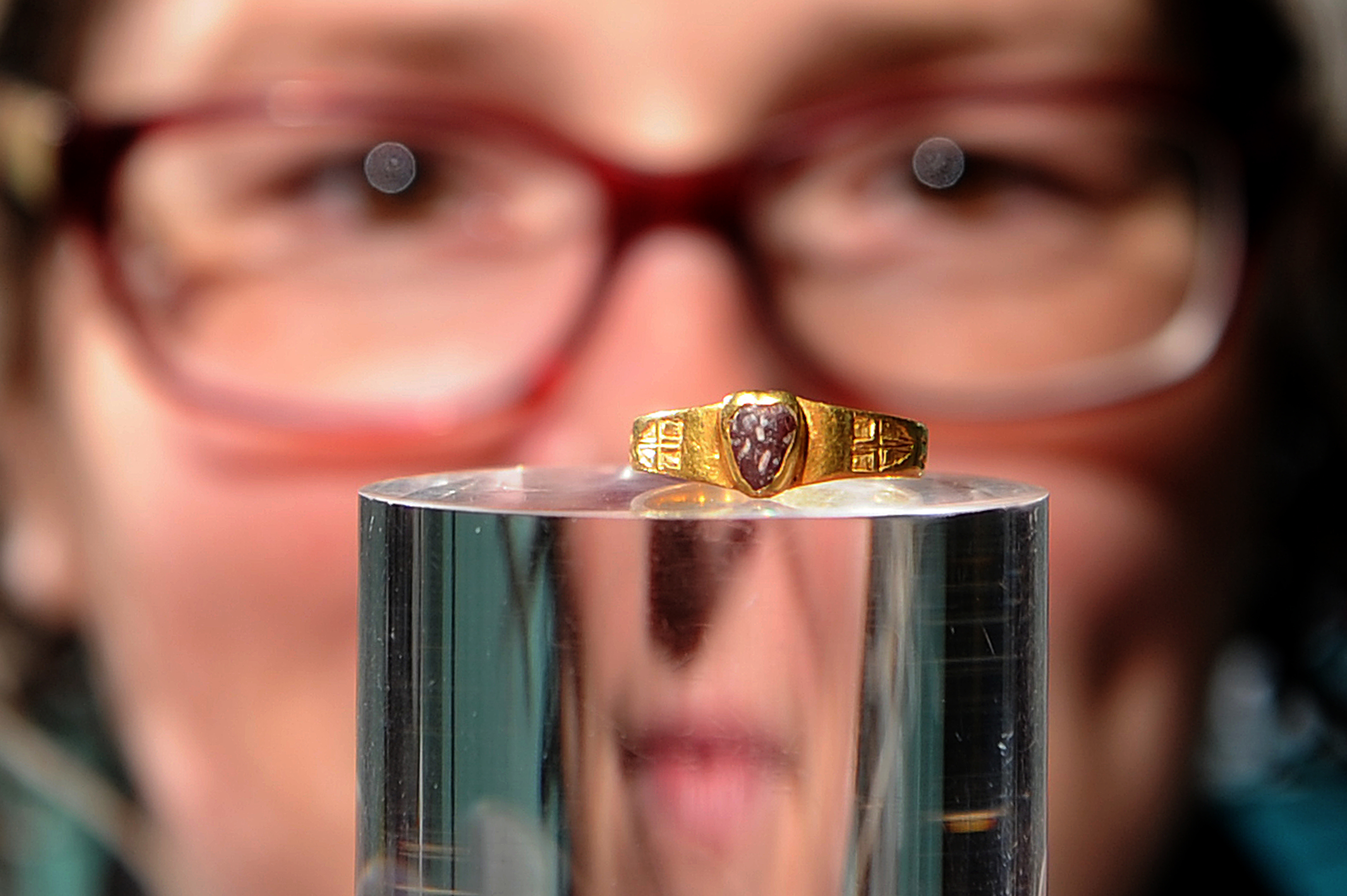 Museum assistant Jen Falconer inspects the ring.