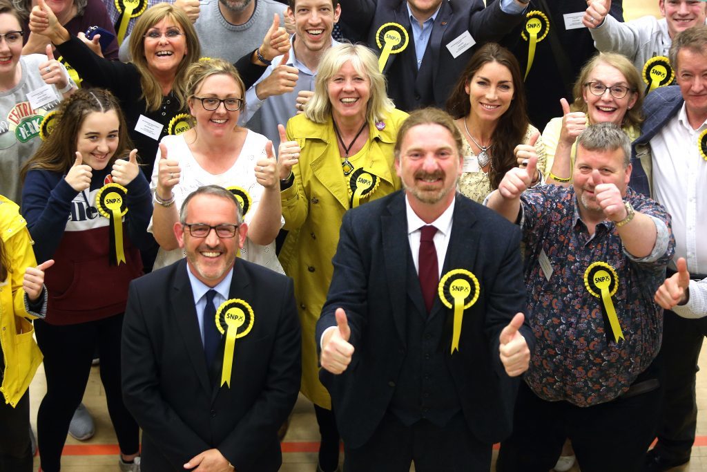 Stewart Hosie and Chris Law celebrate with SNP supporters.