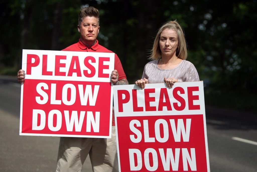Courier News. Jamie Buchanan story. Family and friends of Harlow Edwards, who was tragically killed by a speeding driver last year, gathered to ask drivers to slow down and ask Perth and Kinross council to implement the traffic calming measures they have promised. Picture shows; Steven and Sara Edwards (Harlow Edwards parents) with their simple message 'Please Slow Down'. Friday, 2nd June, 2017.