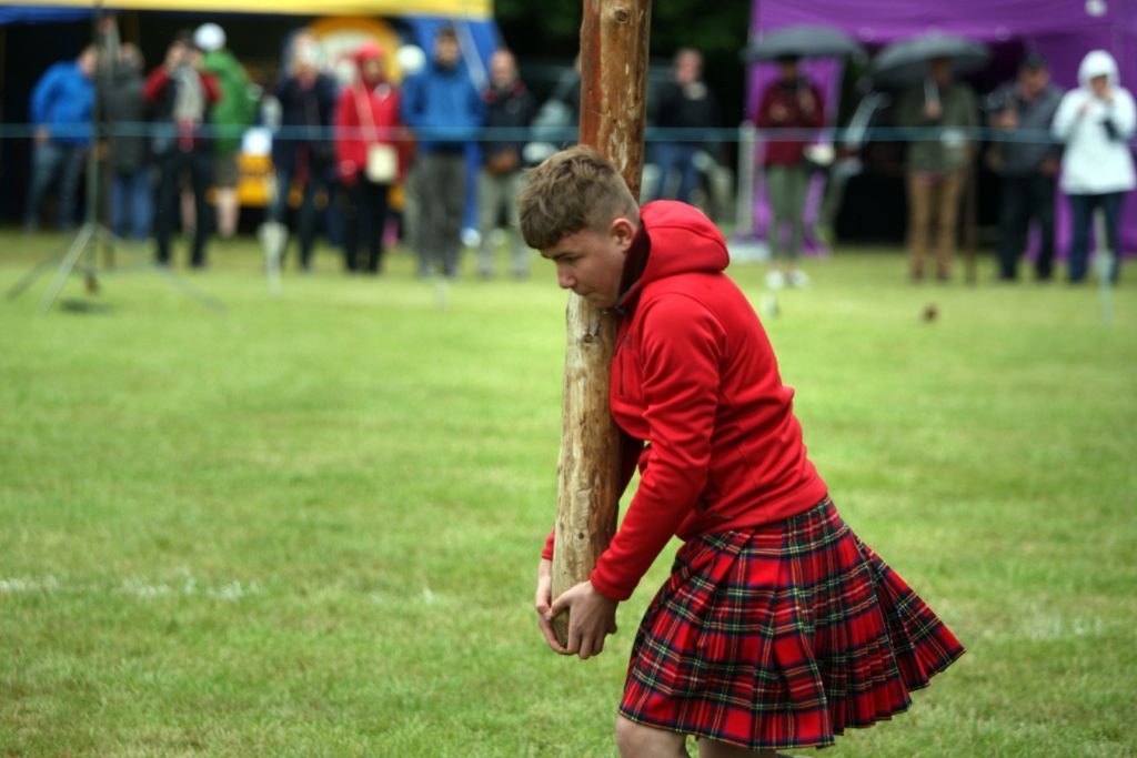 One of the junior competitors tossing a caber.