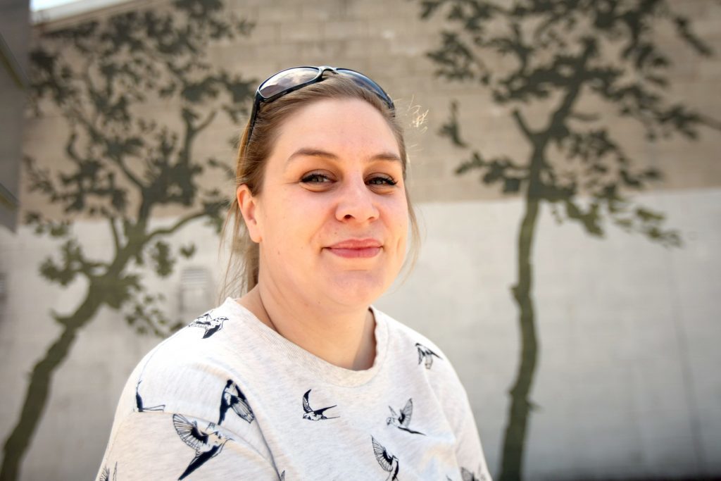 UNESCOs Annie Marrs beside her favourite public art, sand blasted trees on a building in Brown Street. 