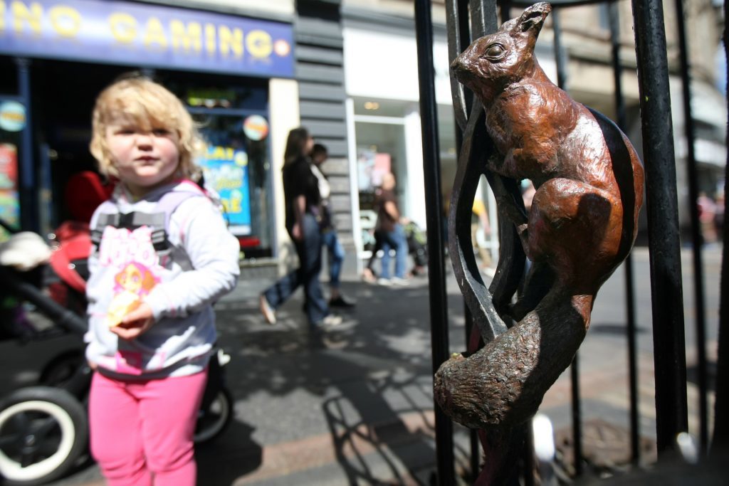 Iona Hail finds the bronze squirrel in a tree in Dundee's High Street.