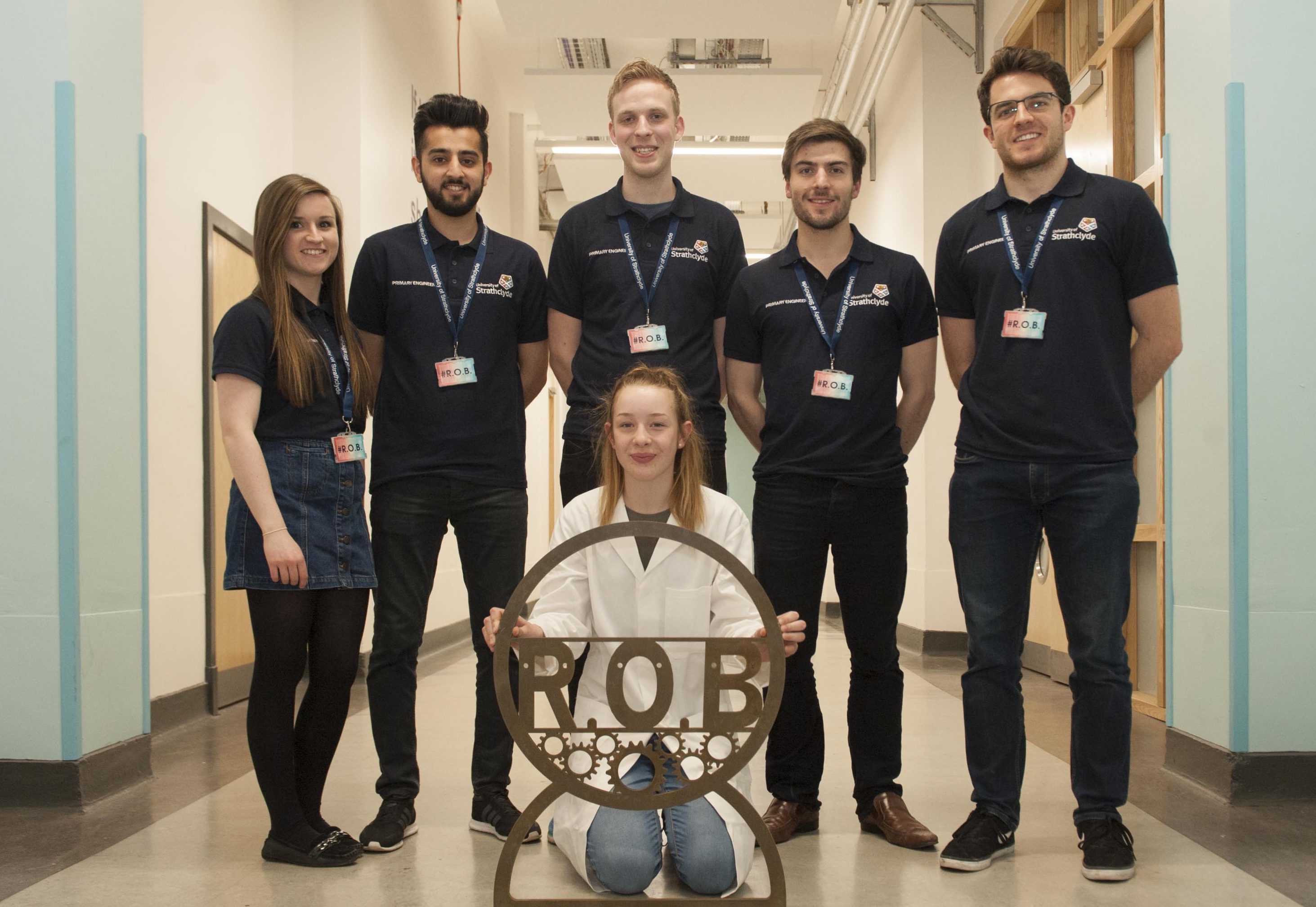 Grace Finlay, Primary Engineer invention winner, with part of her Roll Over Bench invention, and University of Strathclyde's Engineering students, who are helping to build it