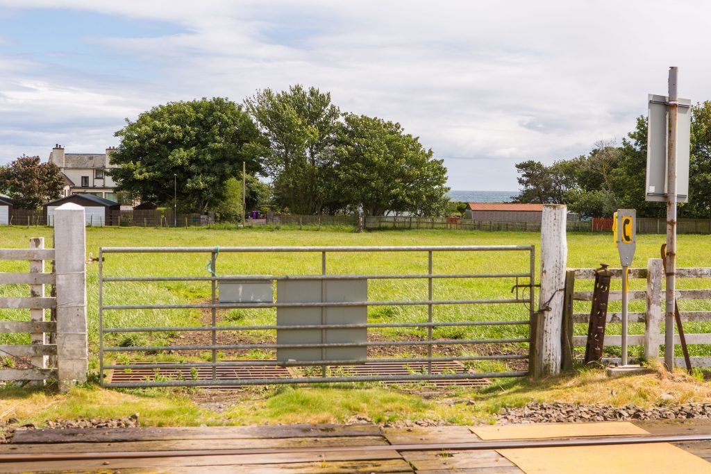 The field beyond the railway track that is to be made into a permanent ambulance track for safe passage.