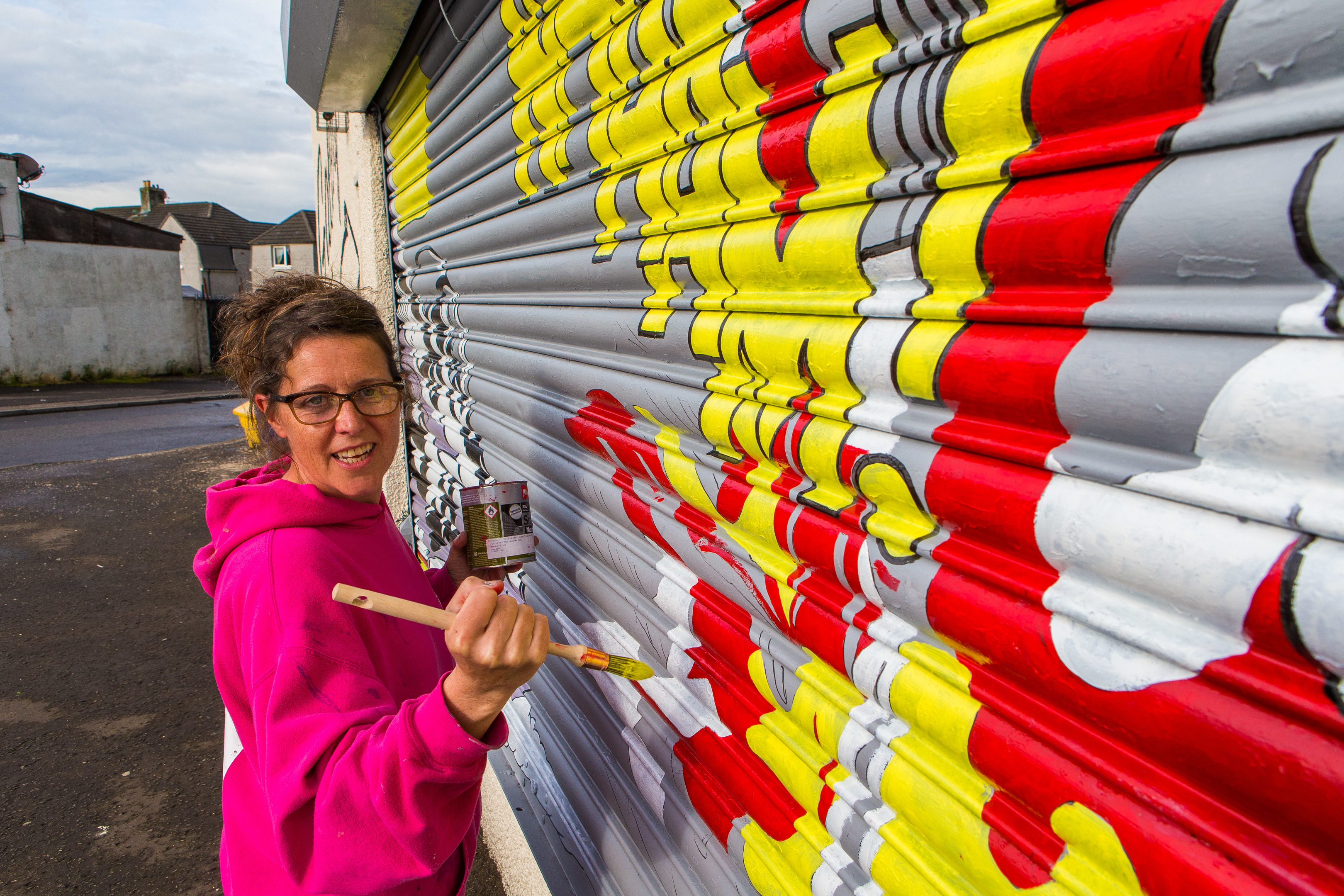 Painter Celie Byrne at a previously painter shutter in Kelty