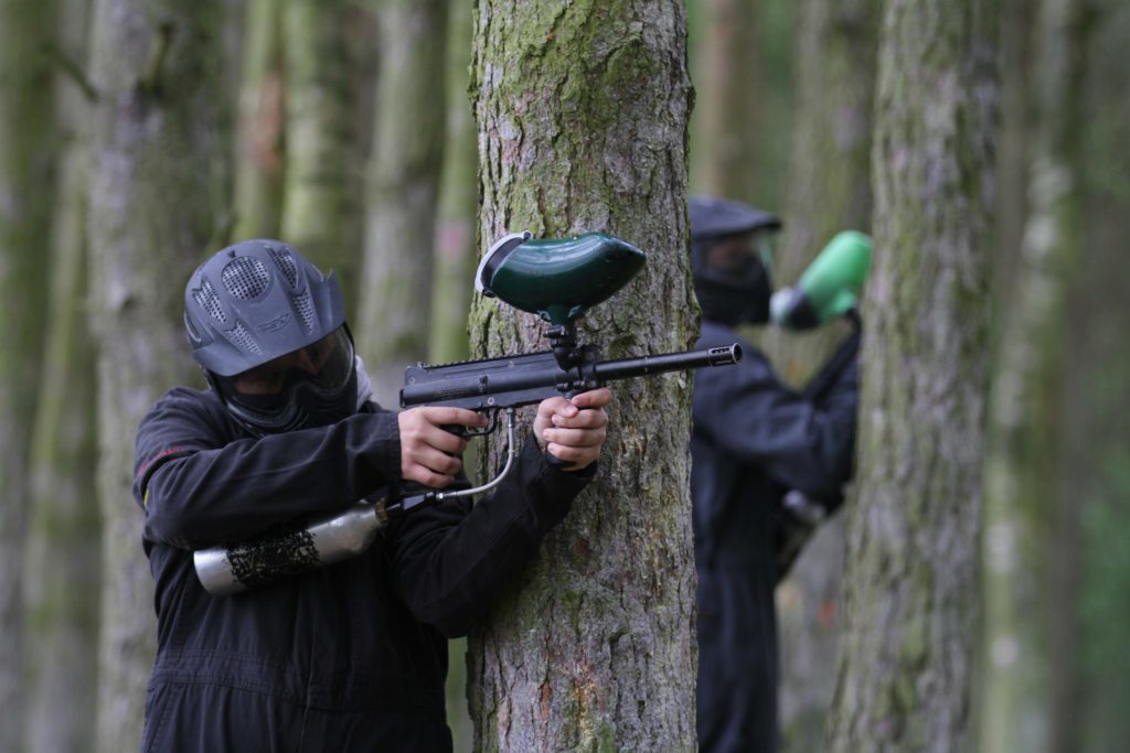 A paintball player preparing to take aim.