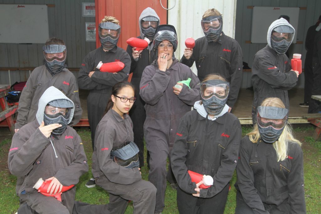 Students from Madras College in St Andrews flank Gayle ahead of a paintballing session.