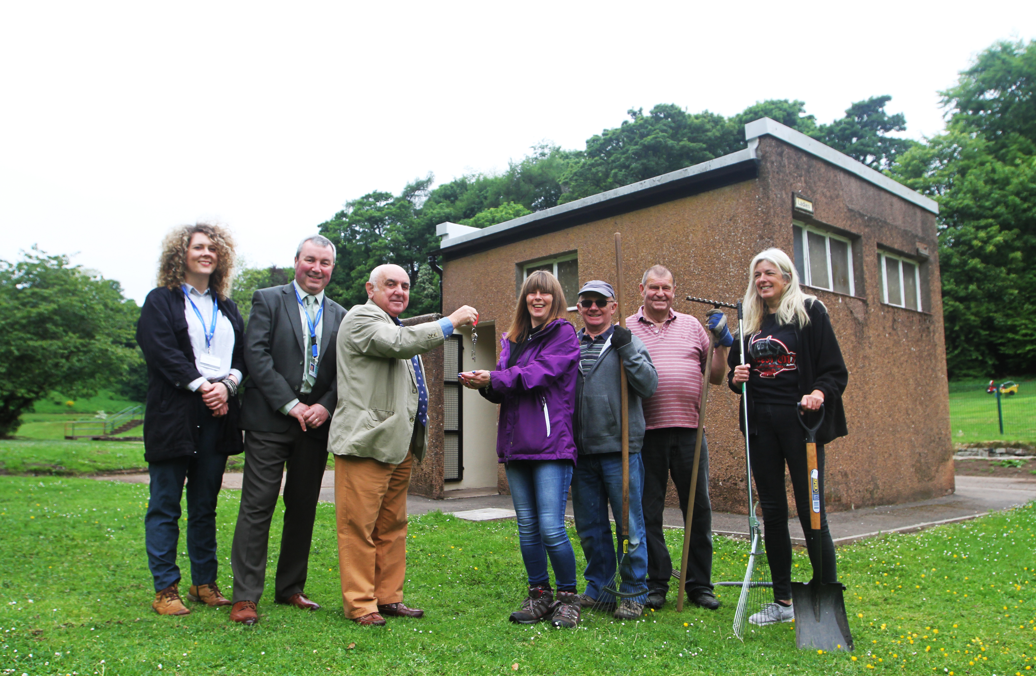 Angus Provost Ronnie Proctor hands the keys to The Den loos to KRG members