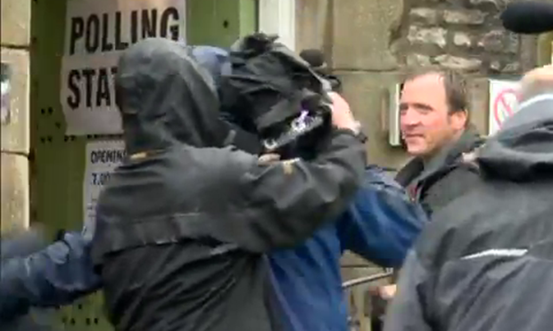 The photographer disappears stage left after being shoved by a TV rival.