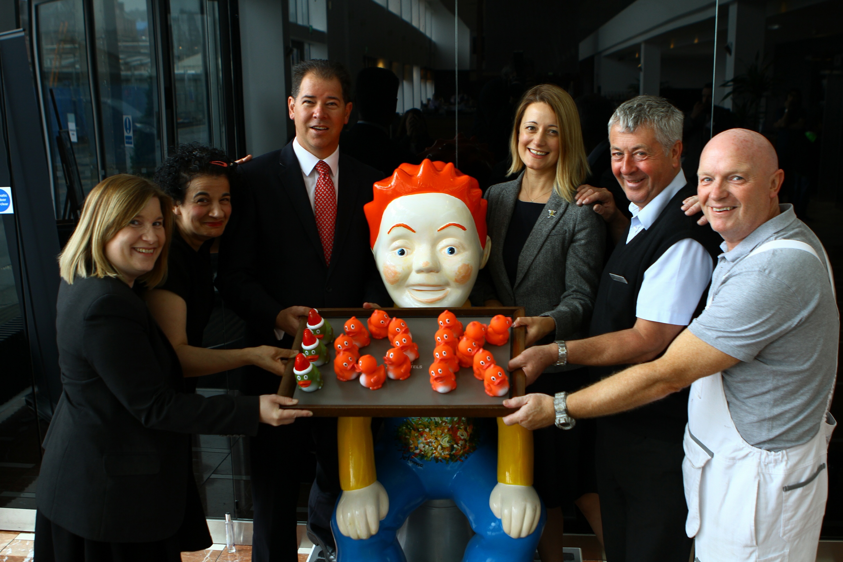 Lyndesy Gibson, front office manager, Esa Bougern senior spa therapist, Brett Davidge, Apex hotel general manager, Cassie Thompson, director of fundraising at ARCHIE,  with Jim McWilliams , maintenance manager and Steve Keillor the Apex's painter and decorator, beside the Oor Jolomo statue in the Apex Hotel in 2017.