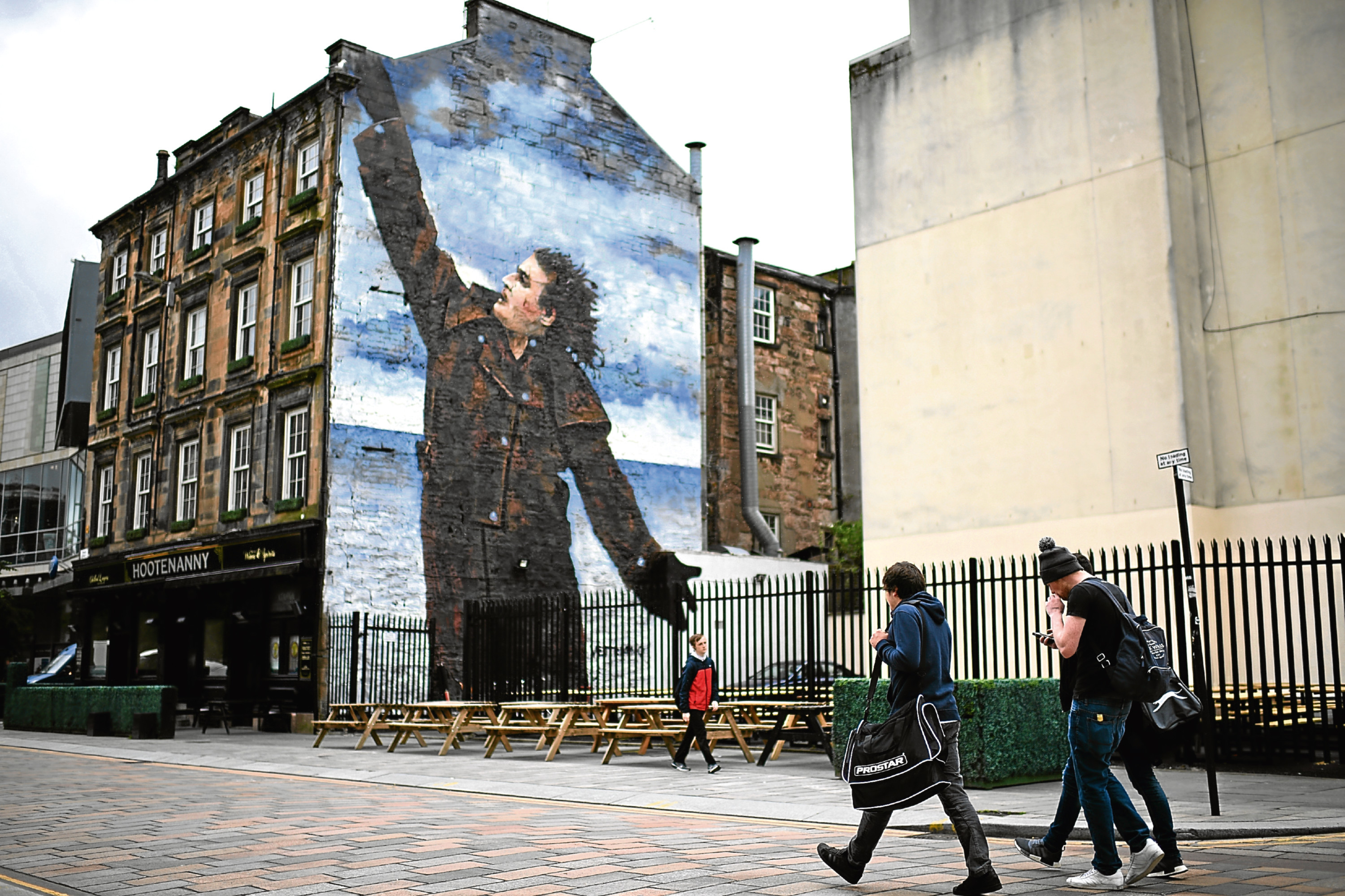 A mural of comedian Billy Connolly displayed on a gable wall in Glasgow.