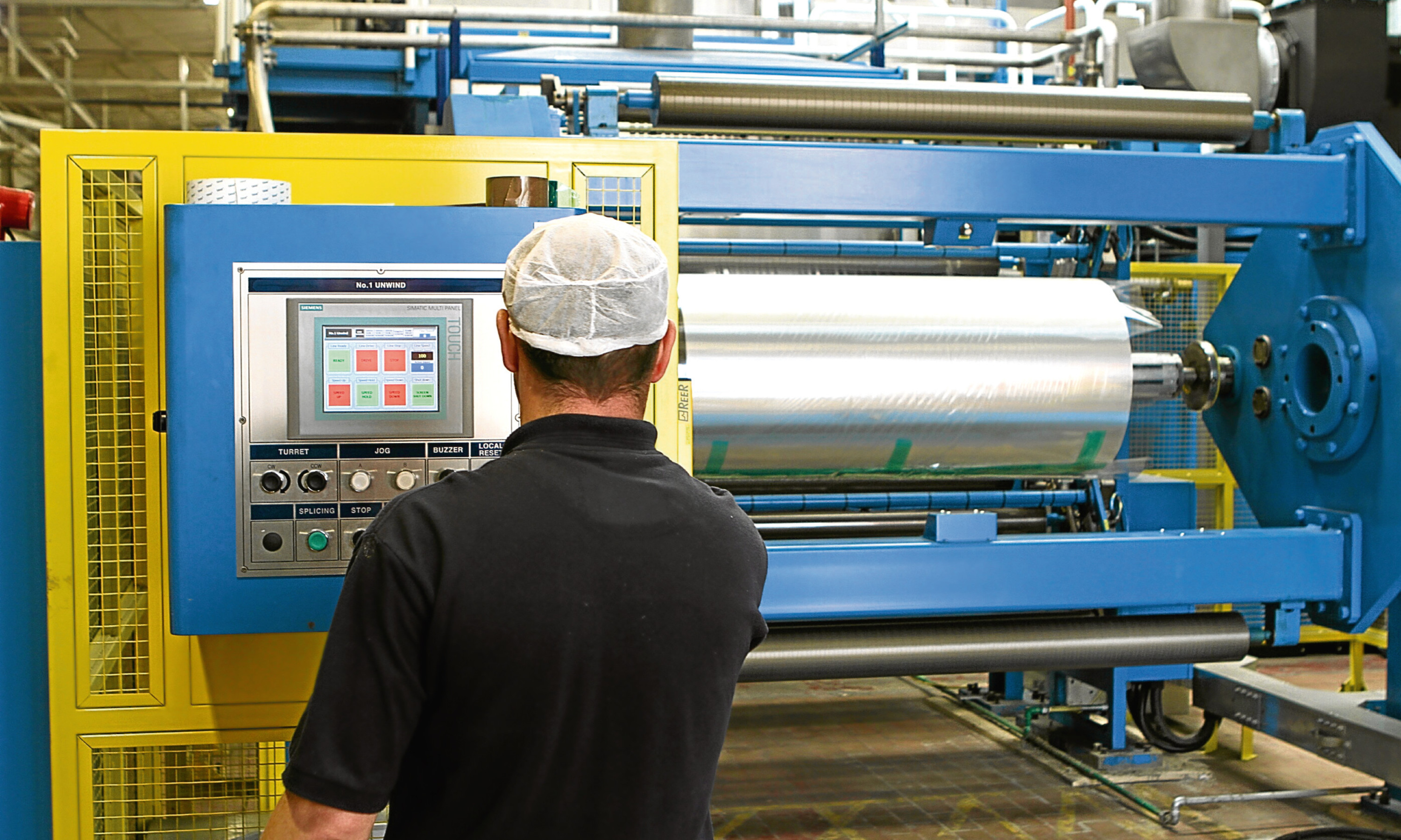 A technician changes a roll of film on Rockwell Solutions 'Rockstar' machine.