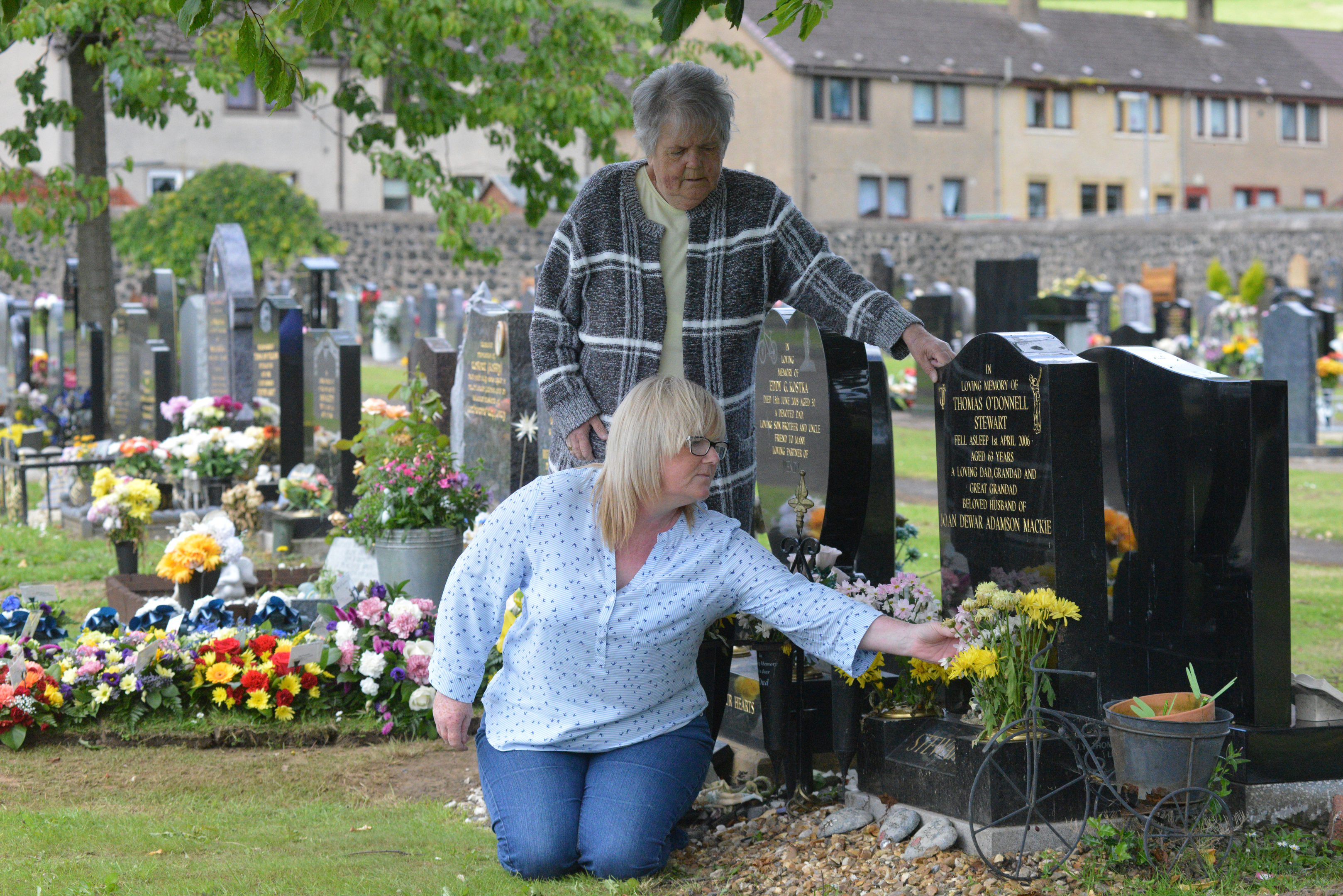 Carolanne Stewart, with mother Joan, tend her father's grave after the distress of his spot being used to store soil