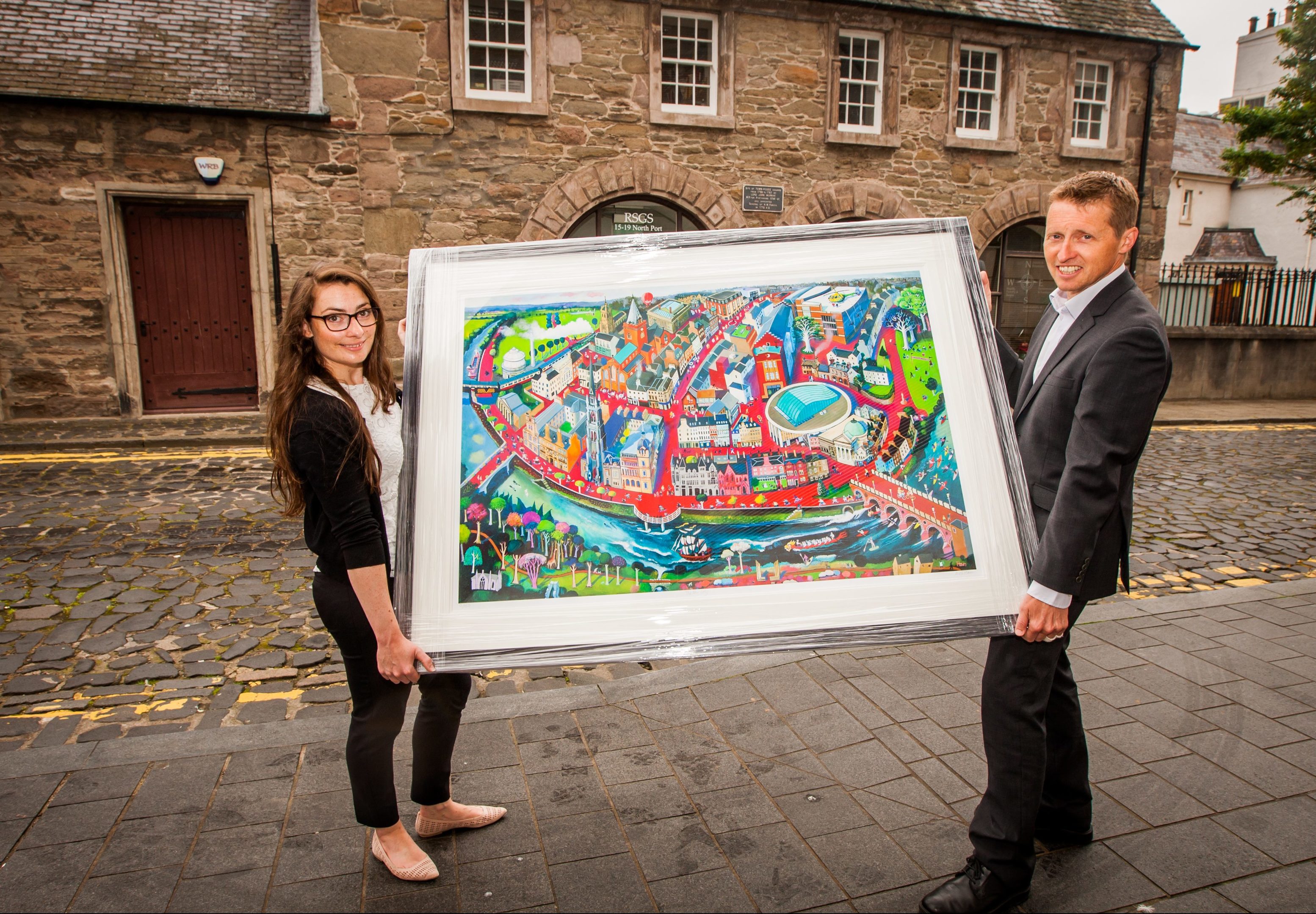 Gemma McDonald (RSGS communications officer) alongside chief executive, Mike Robinson and the painting 'Fair City' at the Royal Scottish Geographical Society, North Port, Perth.