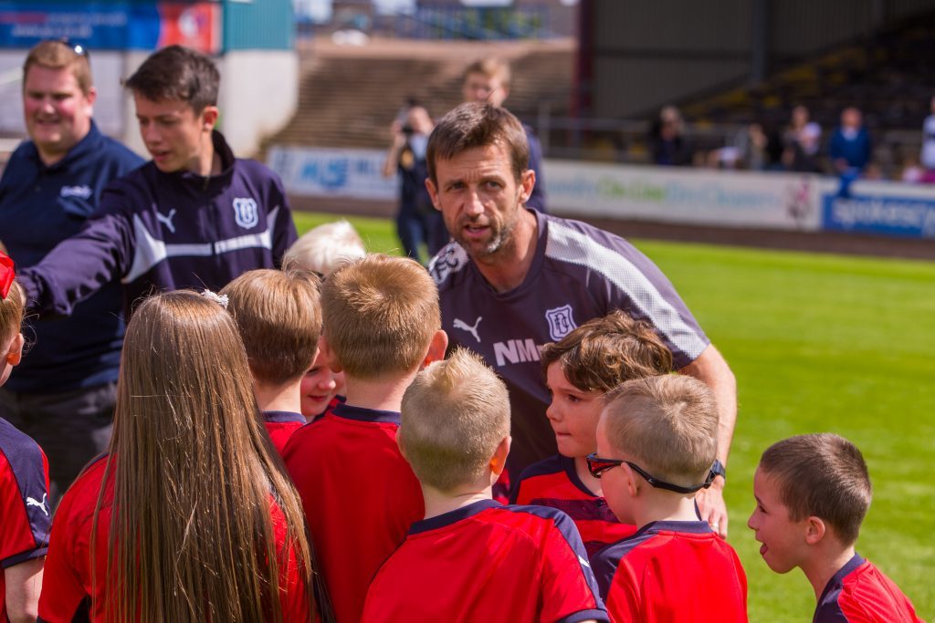 Dundee Manager Neil McCann talks tactics to the kids team.
