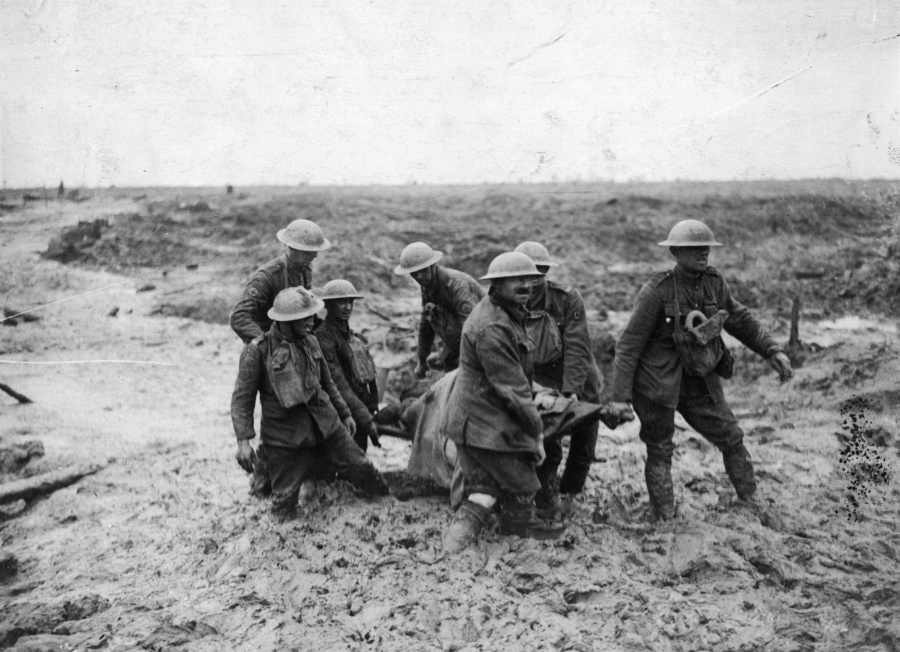 A stretcher party bear a wounded soldier through the mud at Passchendaele.