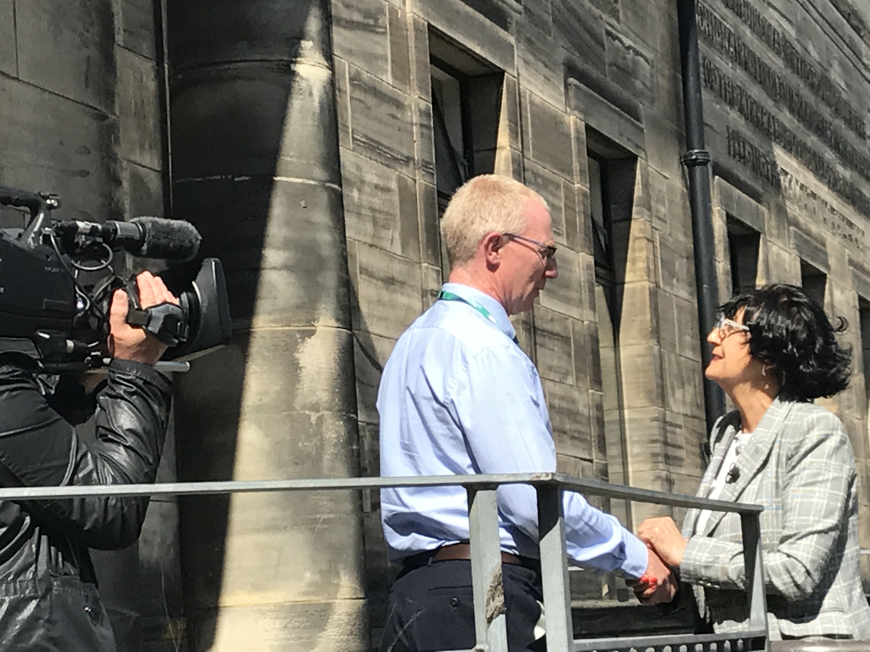 Collections curator Gavin Grant greets Anita Manning on the steps of Kirkcaldy Galleries.