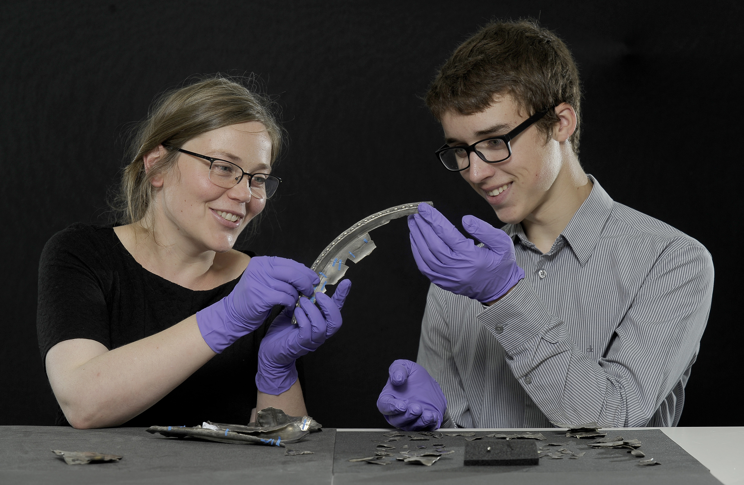 Metal detectorist David Hall, then 16, examines the Dairsie Hoard, a hoard of Roman era silver he unearthed in Fife, with Glenmorangie Research Fellow Alice Blackwell of National Museums Scotland in 2017.