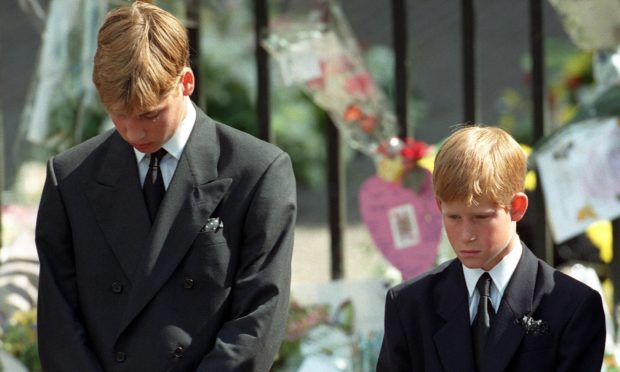 Prince William (left) and Prince Harry, the sons of Diana, Princess of Wales, bow their heads as their mother's coffin is taken out of Westminster Abbey following her funeral service.