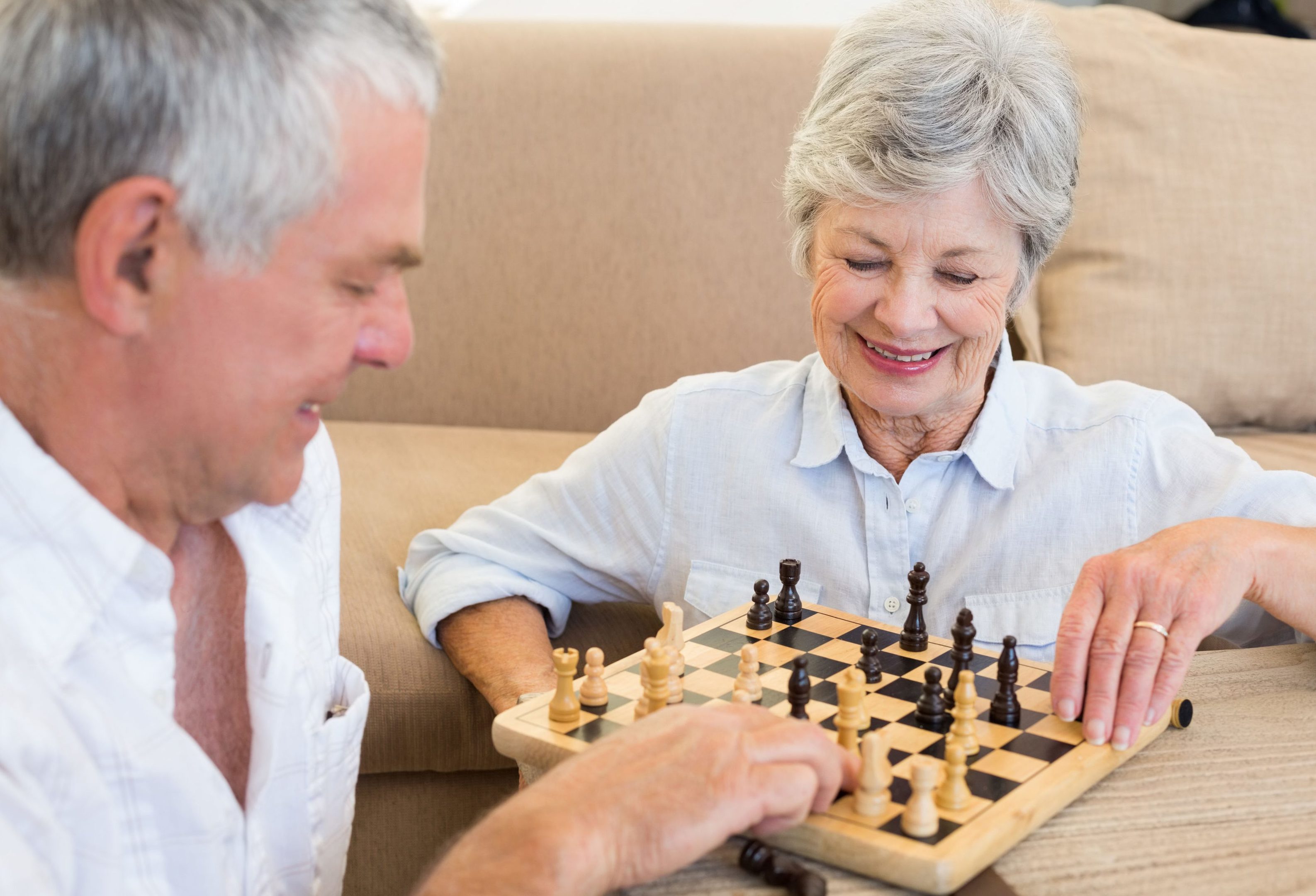 An older couple playing chess together. But what is the secret to a happy retirement?