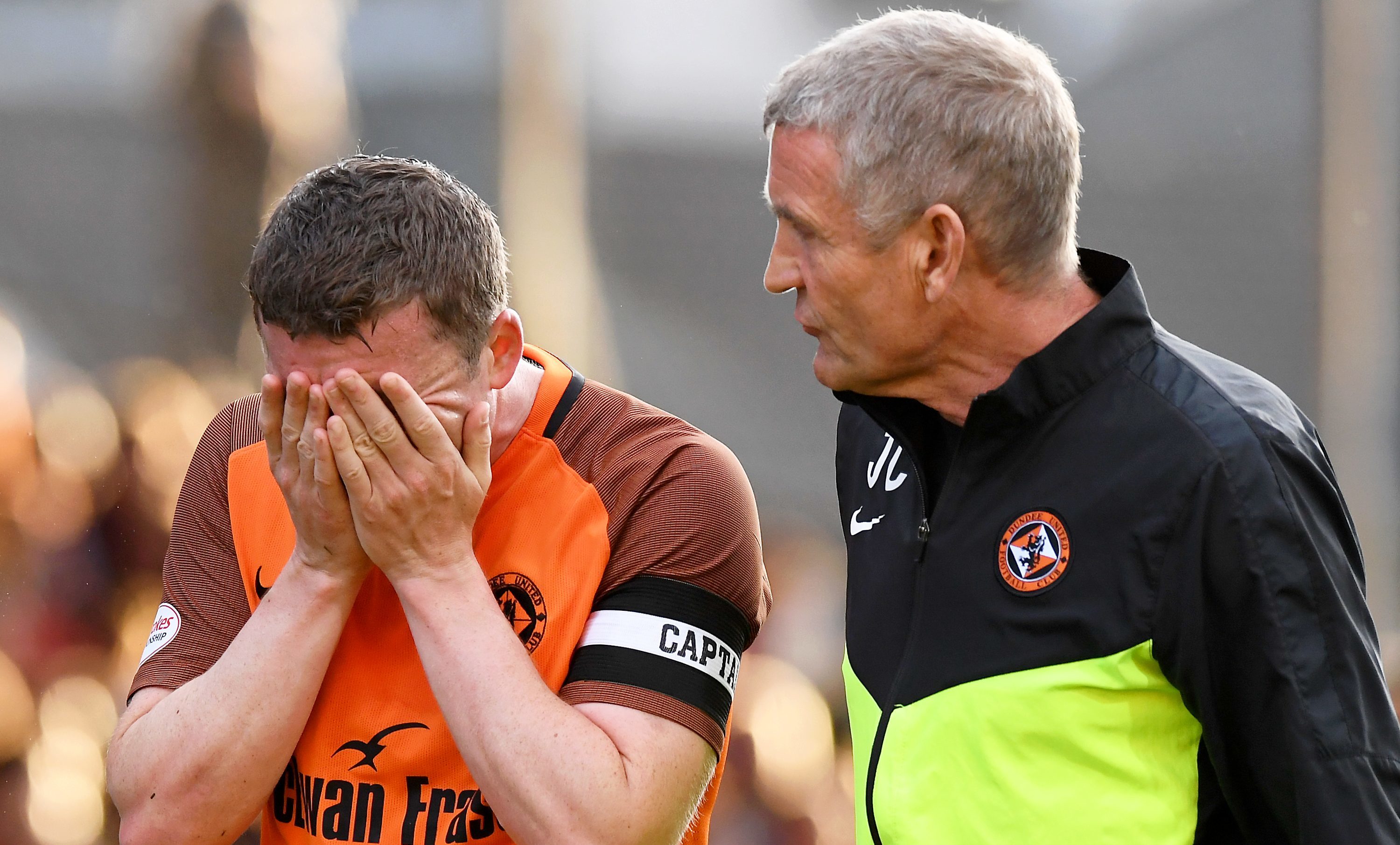 Tam Scobbie with United physio Jeff Clarke after suffering the injury.