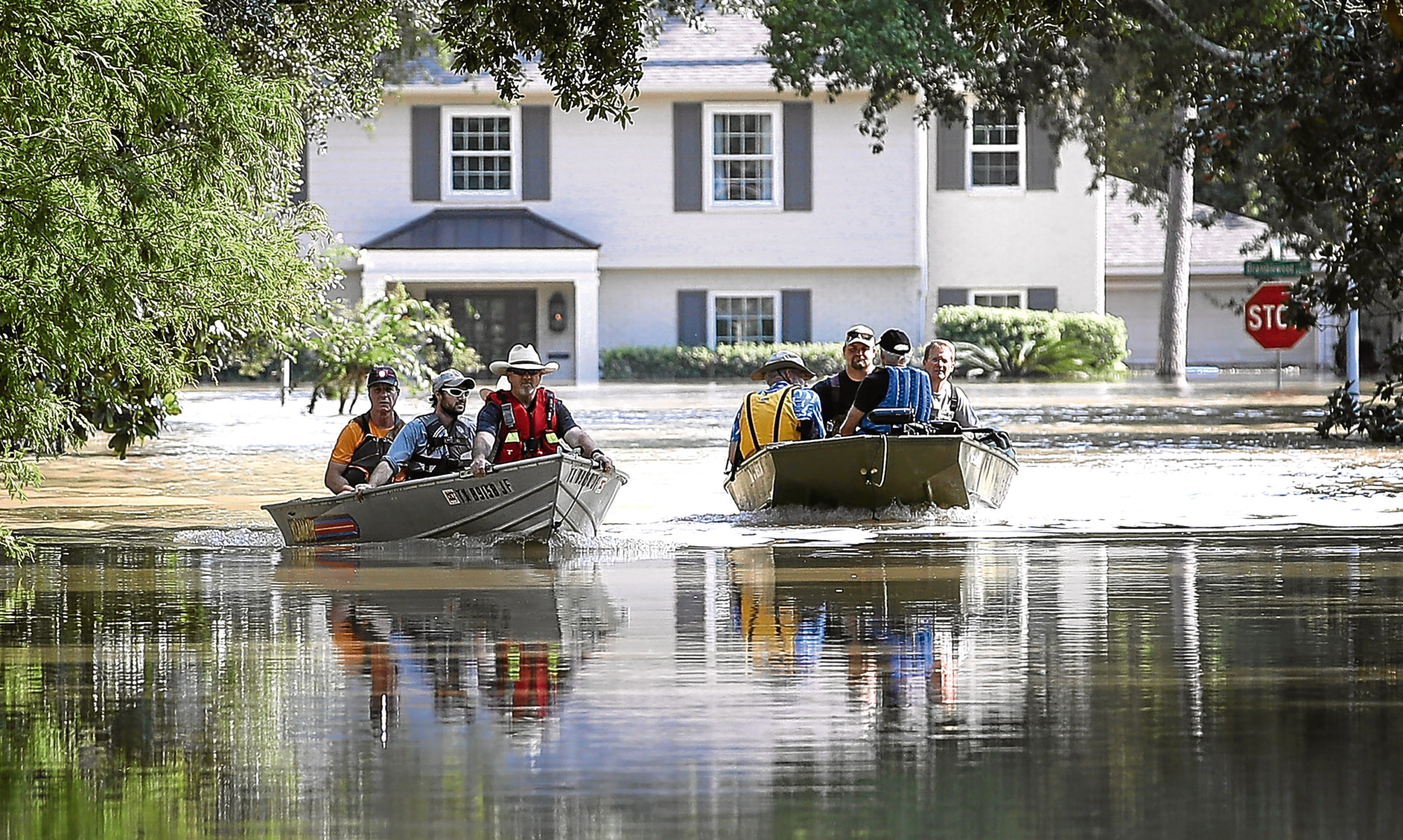 Residents near the Barker Reservoir, Houston, Texas, return to their flooded homes to collect belongings.