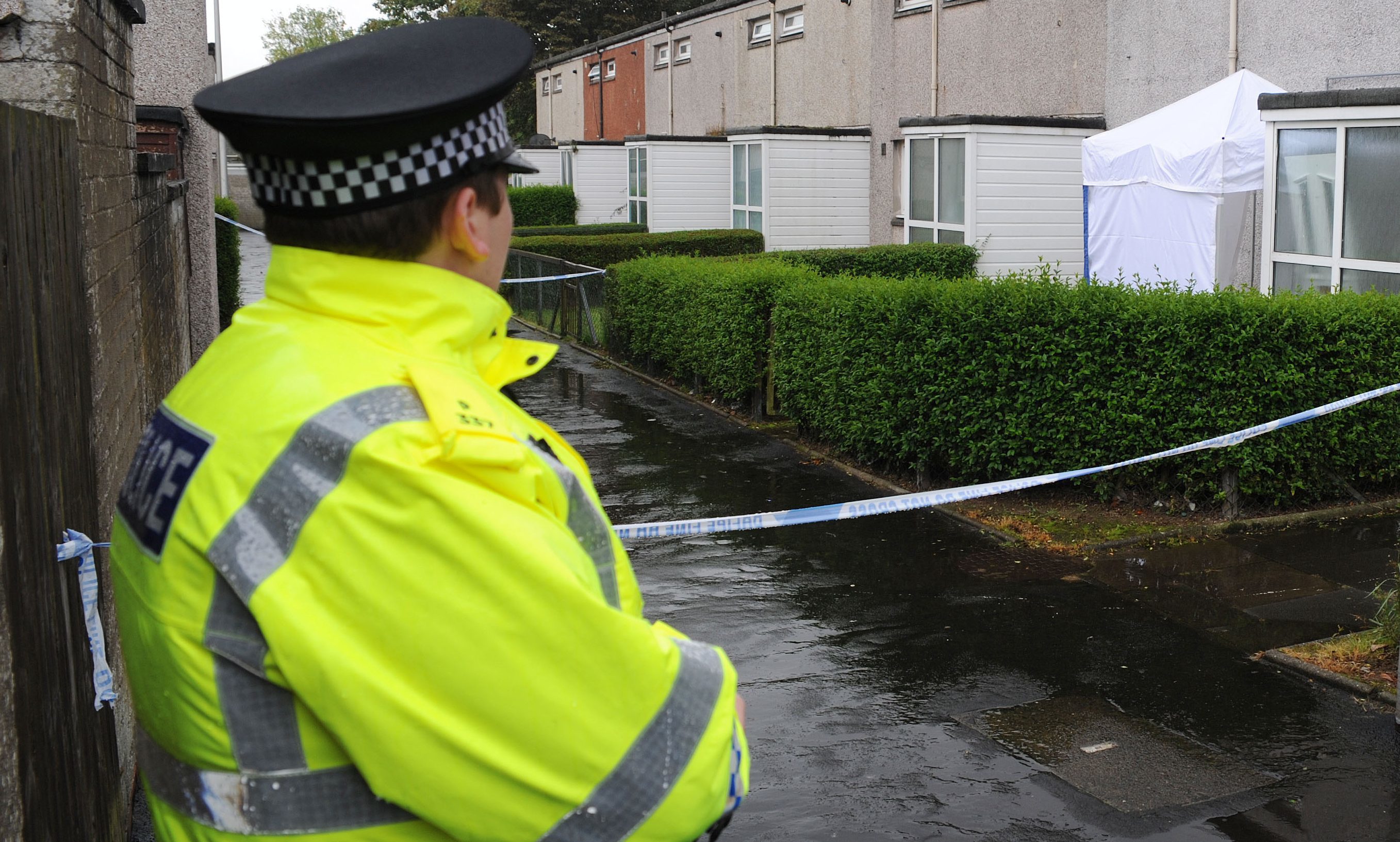 Police guard the house in Glenrothes where the body was found.