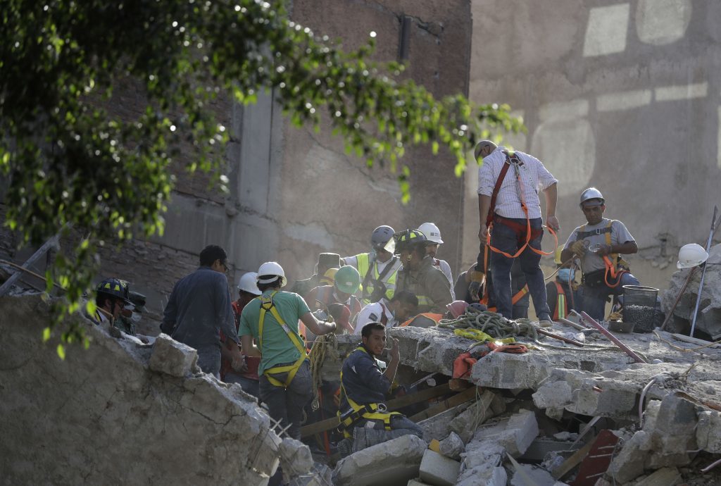 A man calls for a gas mask as rescue workers search for people trapped in the rubble of a collapsed building in the Condesa neighborhood of Mexico City