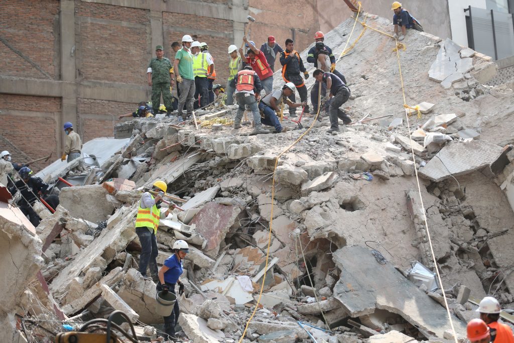 First responders work on removing the rubble of a collapsed building looking for survivors trapped underneath