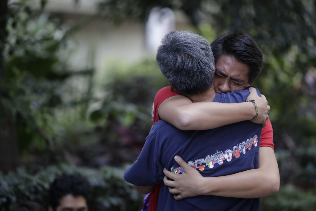 Men hug, crying with joy, as they reunite hours after an earthquake in the Condesa neighborhood of Mexico City