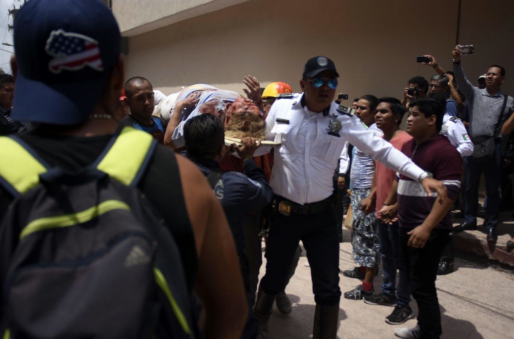 An injured woman is carried on a stretcher after being rescued in Cuernavaca, Morelos state, Mexico