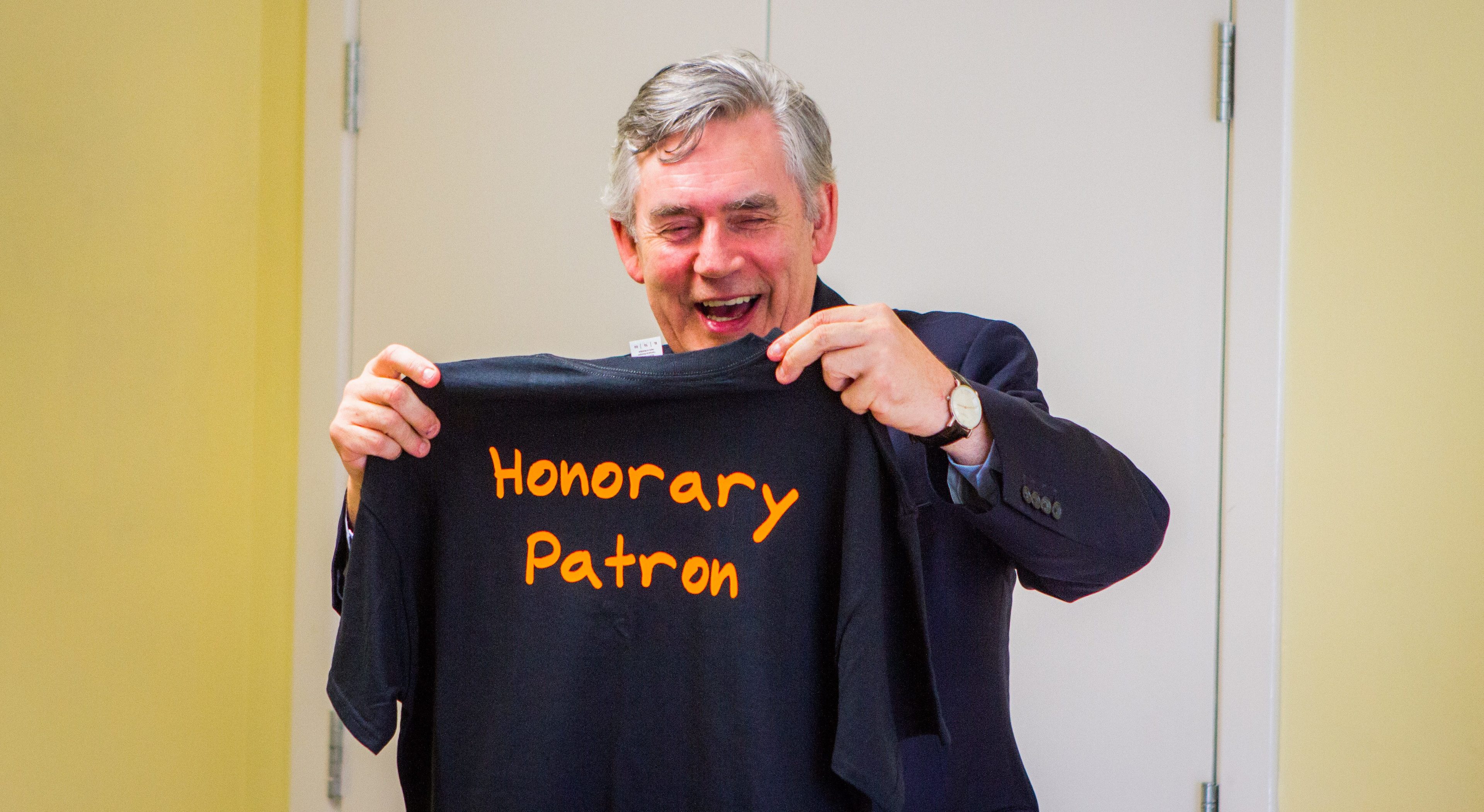 Gordon Brown with a T-shirt that was presented to him as a gift.