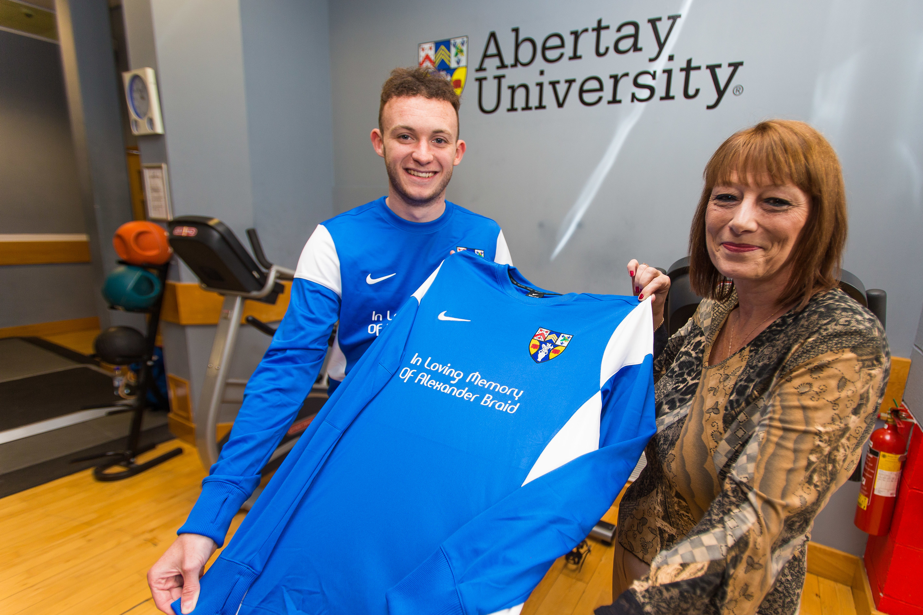 Linda and Adam with one of the football shirts.