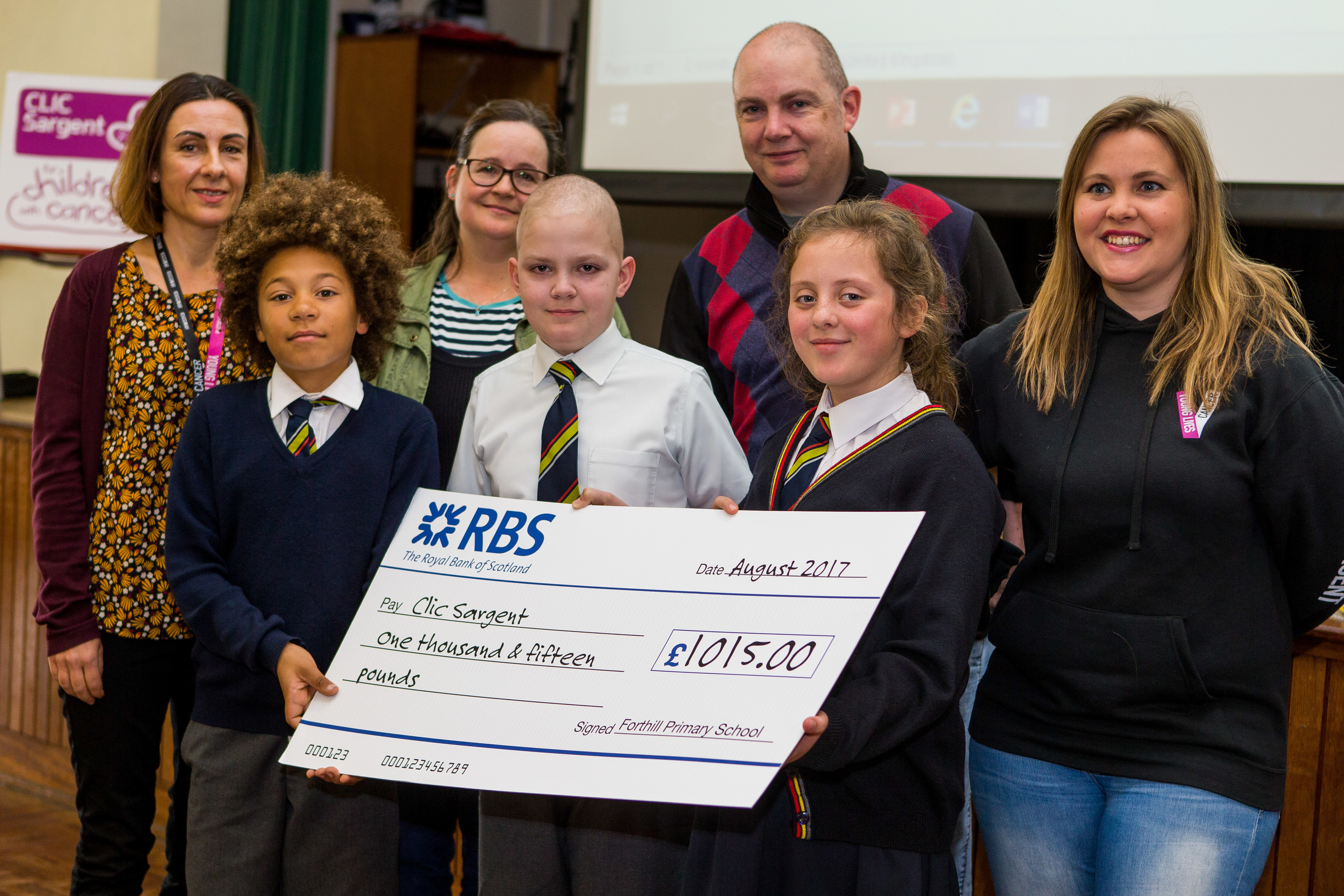 Benny and friends Ethan and Poppy with the cheque, watched by (back, from left) Gail Fawcus of CLIC Sargent), mum Clare, dad Ally and Donna Bednark of CLIC.