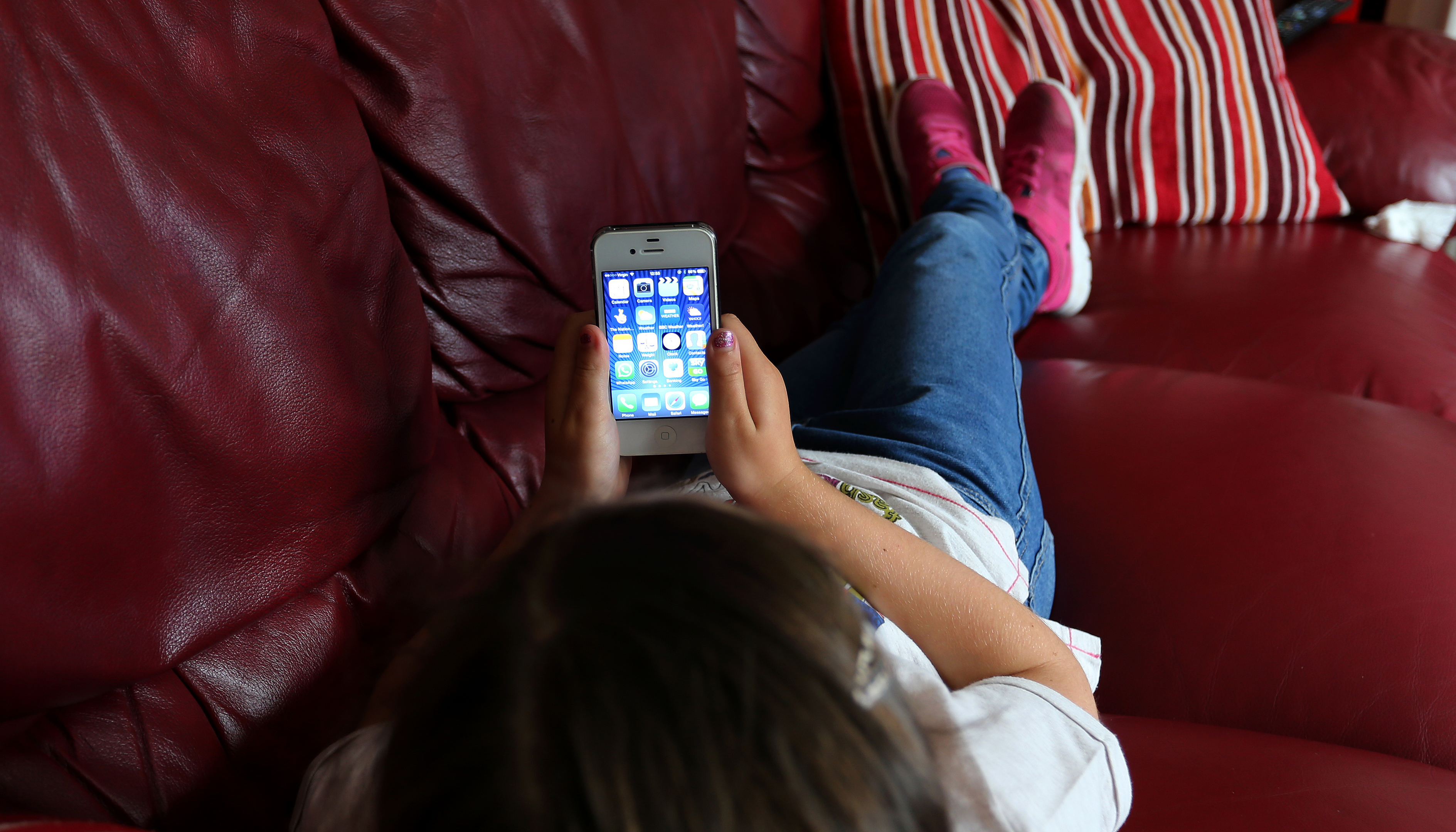 A child using an Apple iPhone smartphone.