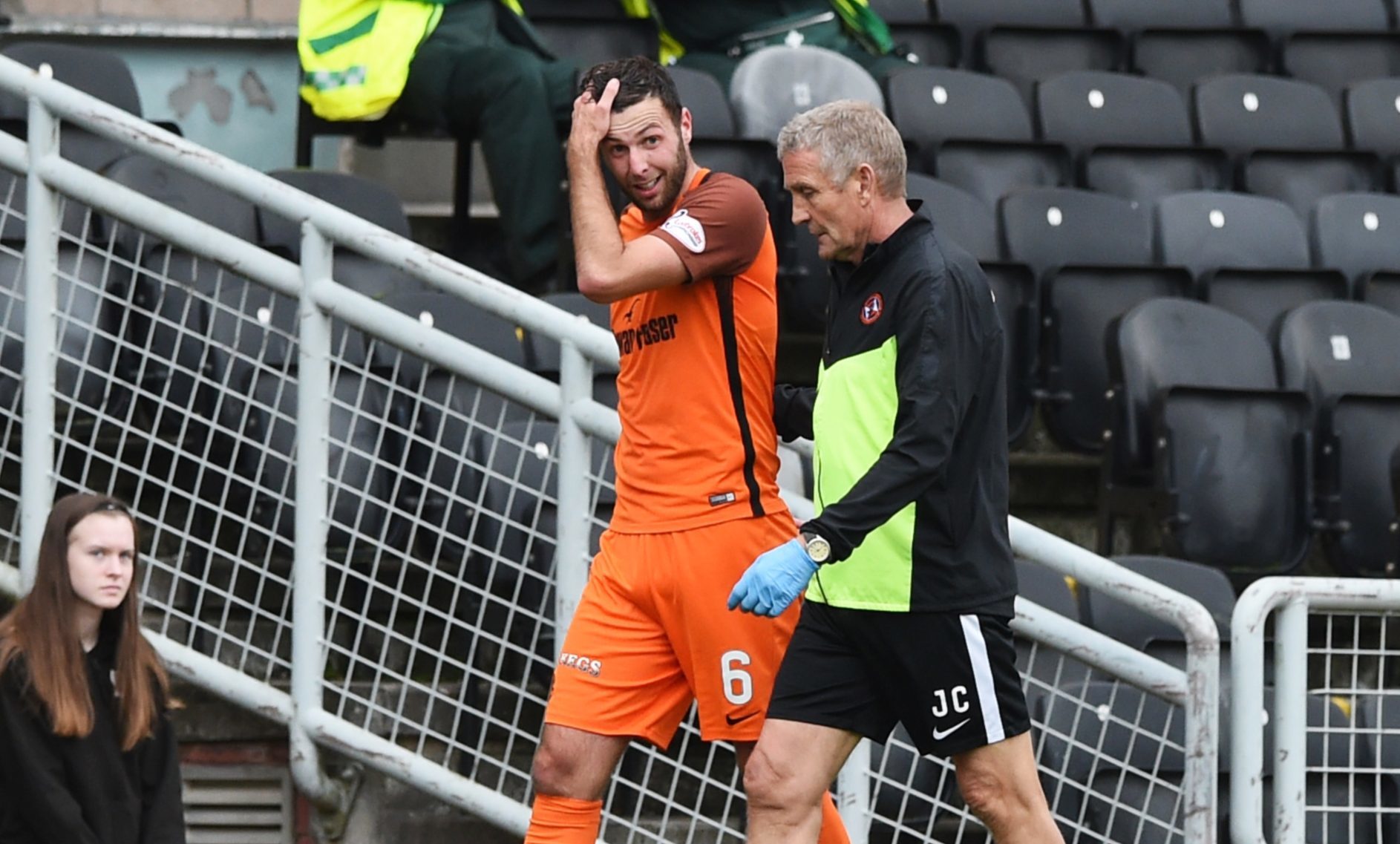 Lewis Toshney walks off with physio Jeff Clarke after hurting his ankle.