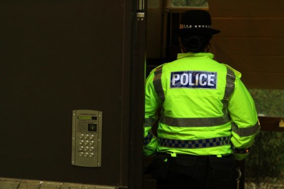 Police at the front door of the block on Nursery Road in Broughty Ferry.