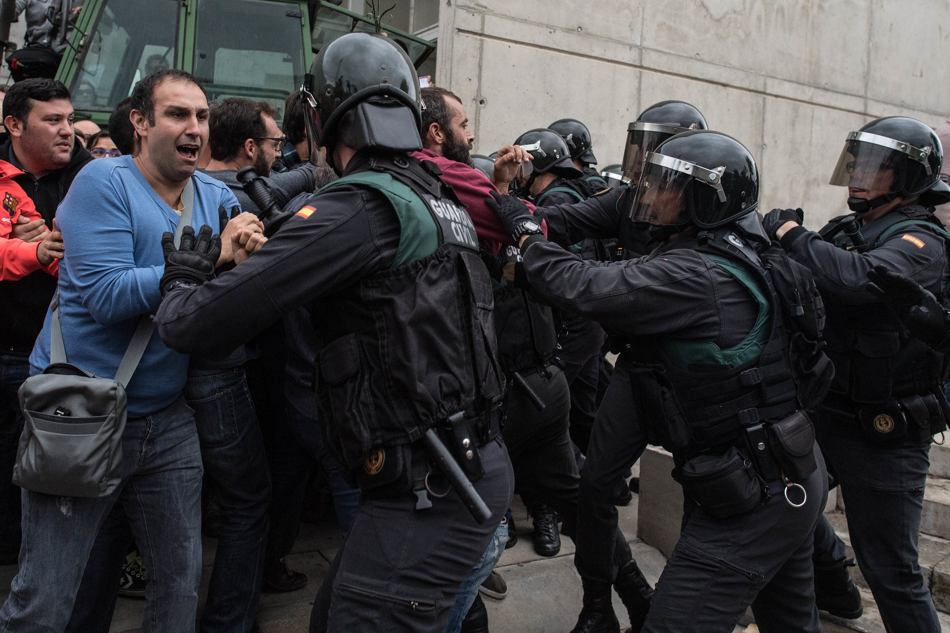 Police move in on members of the public gathered outside to prevent them from voting in the referendum in Sant Julia de Ramis.