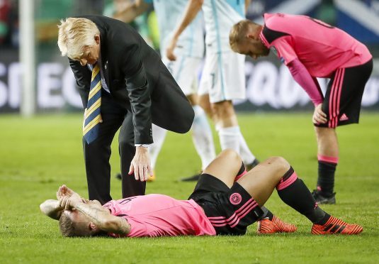 Head coach Gordon Strachan (top) comforts Leigh Griffiths of Scotland after the FIFA 2018 World Cup Qualifier match between Slovenia and Scotland