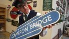 Auctioneer Richard Edmonds with the Cameron Bridge sign.