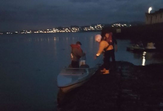 The lifeboat crew helping the stricken sailors to shore following their rescue.