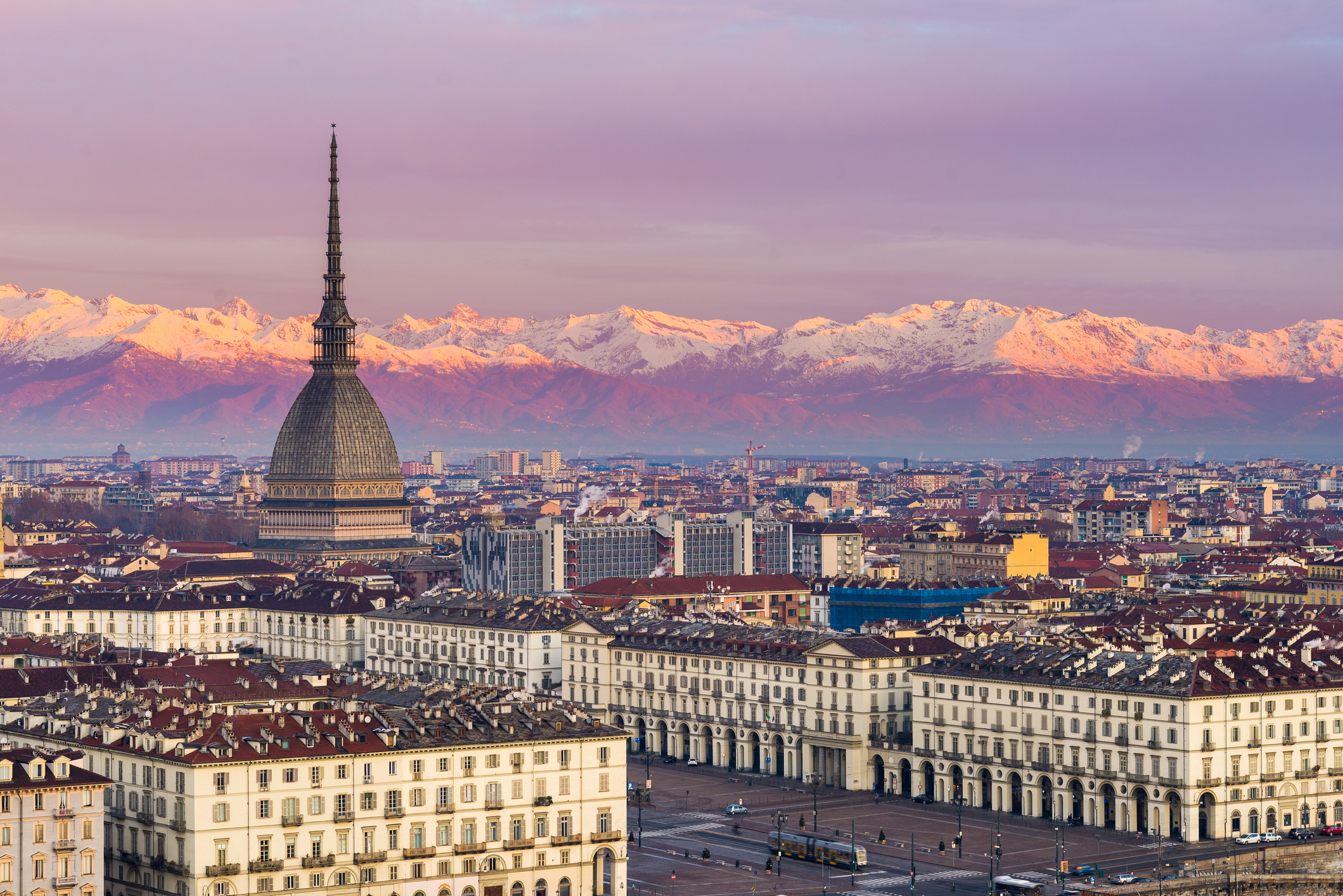 Torino (Turin, Italy): cityscape at sunrise with details of the Mole Antonelliana towering over the city and the snowcapped Alps in the background.